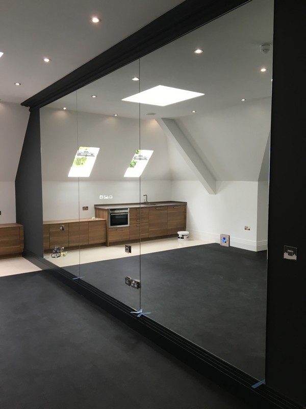 Frameless glass partition in loft conversion by Hackney glaziers
