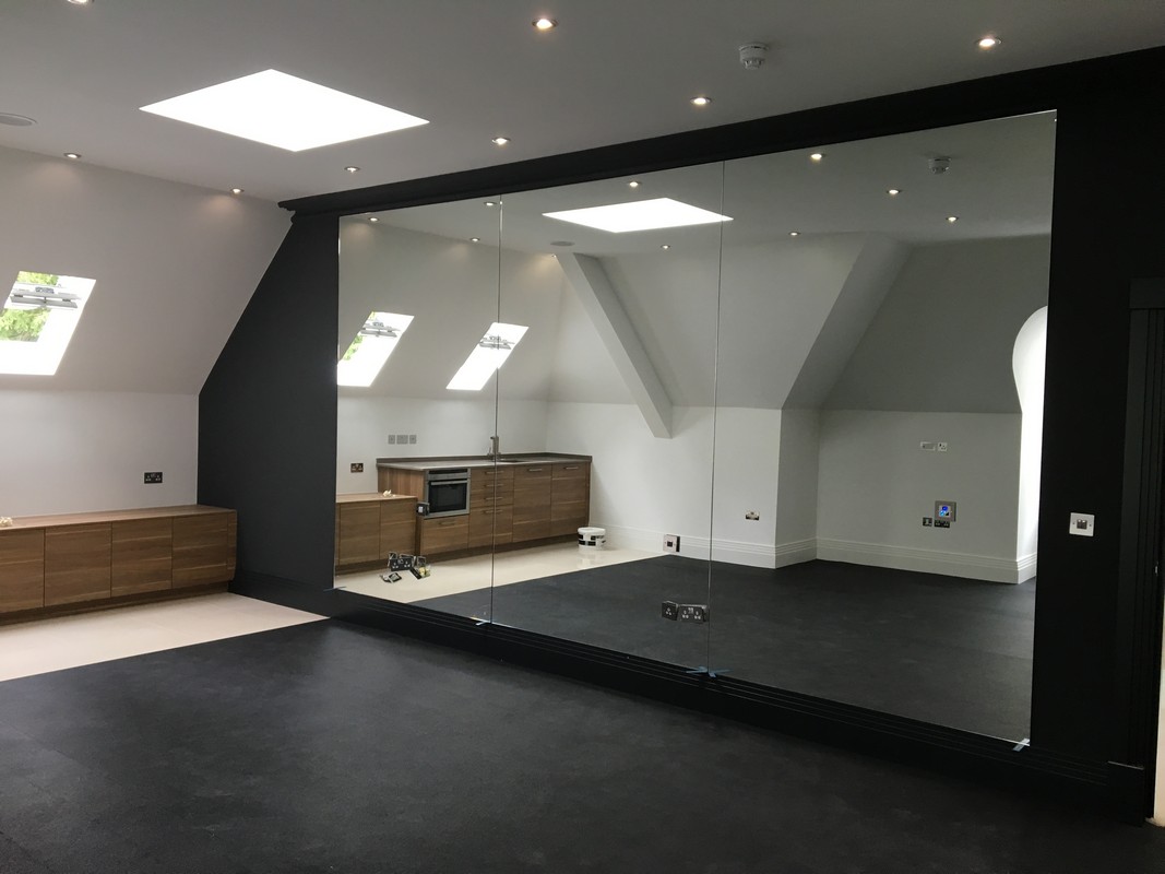 Frameless glass wall dividing loft conversion in Hackney