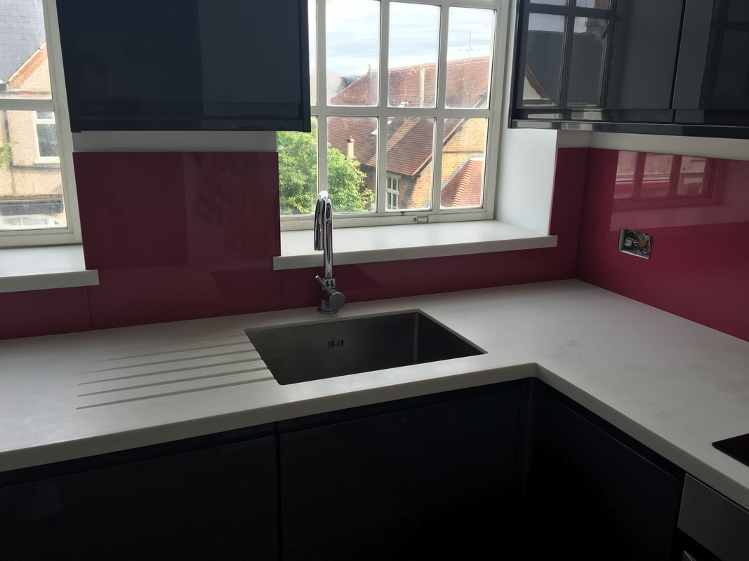 Deep plum coloured glass splashback in modern Hackney kitchen